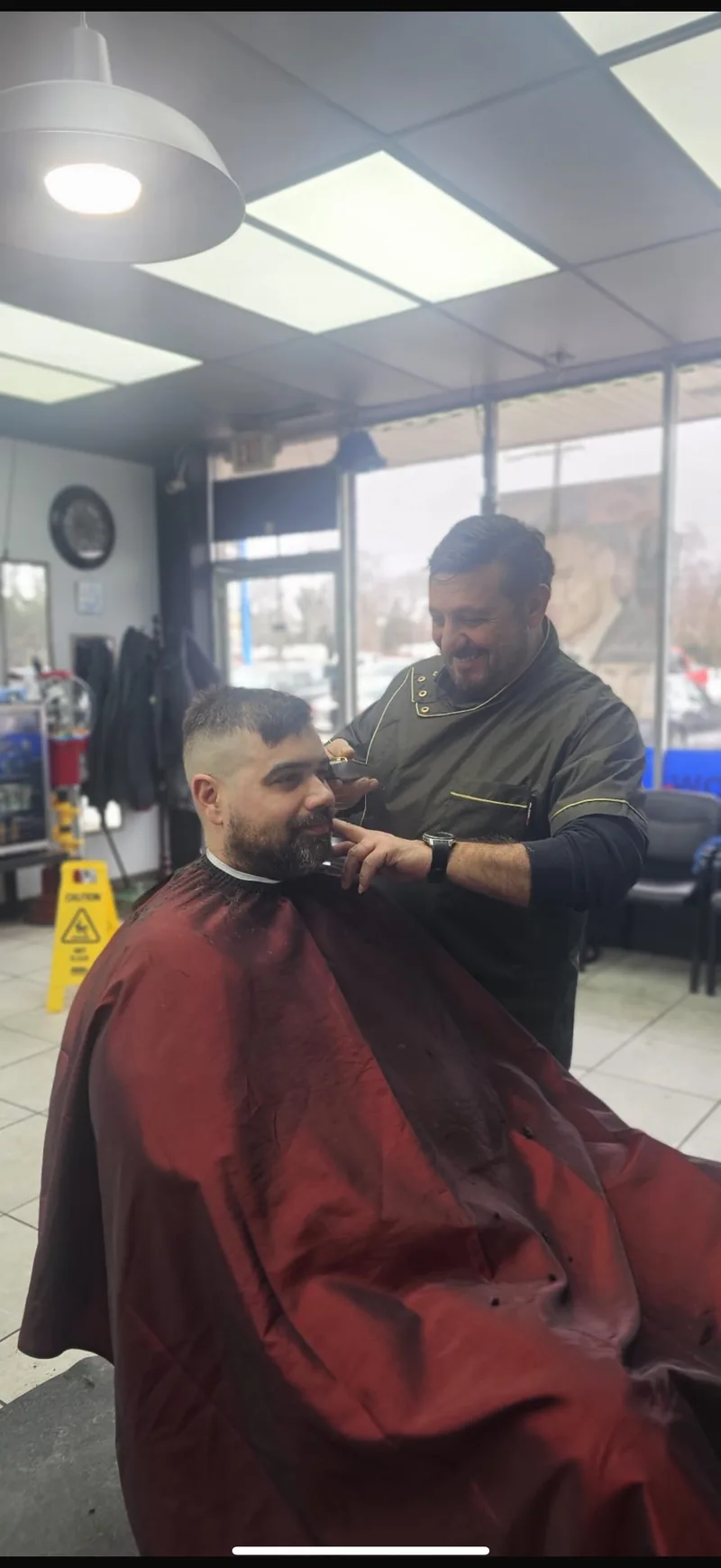 Barber giving a haircut at Fadi's Barbershop Palace Westland Michigan